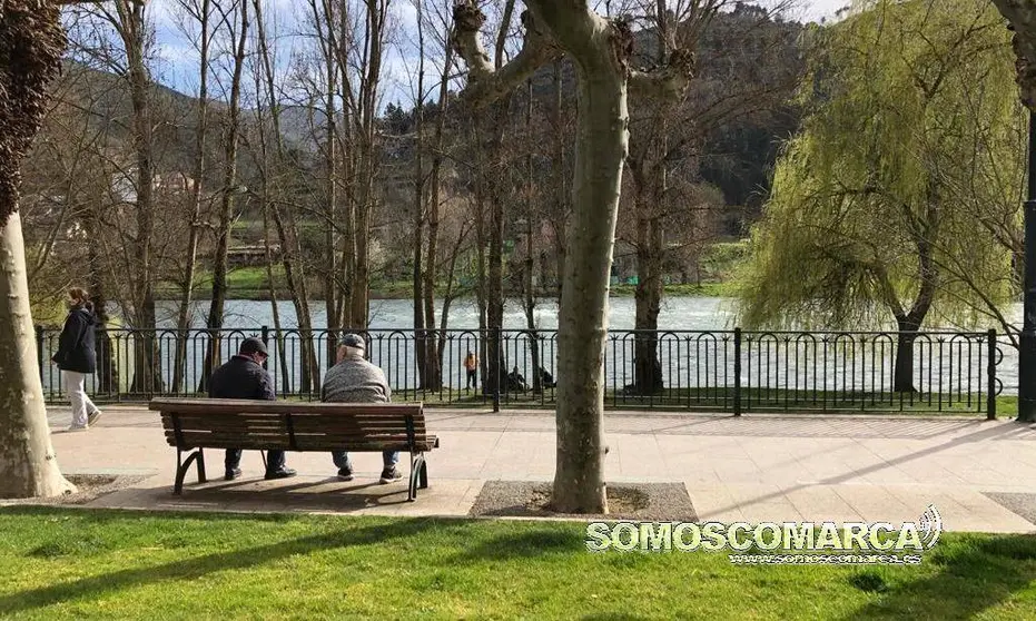 Mayores sentados en banco de Paseo do Malecó