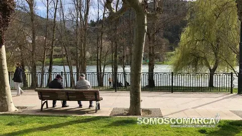 Mayores sentados en banco de Paseo do Malecó